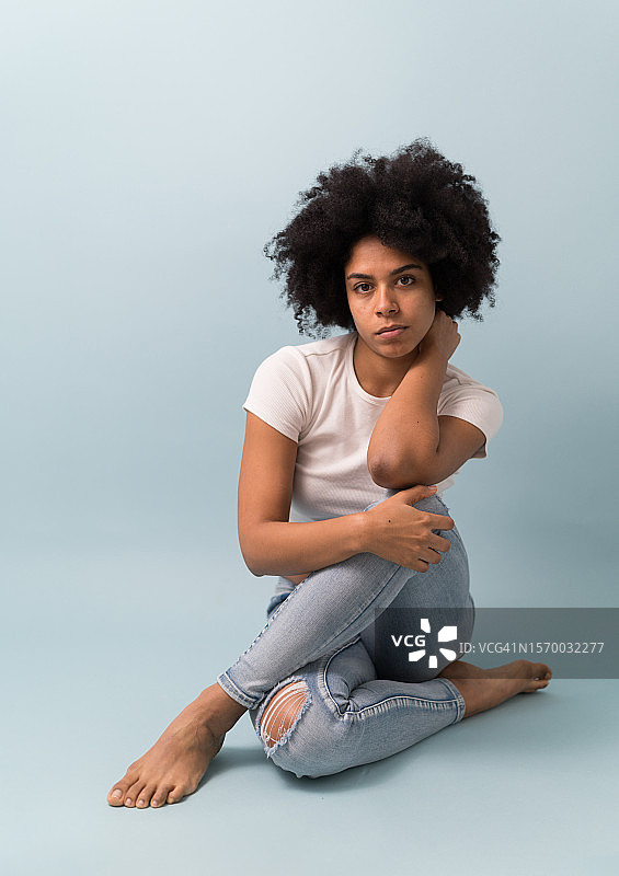 蓝色背景下拥有非洲发型的女人图片素材