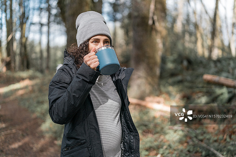 孕妇在徒步旅行时啜饮热饮图片素材