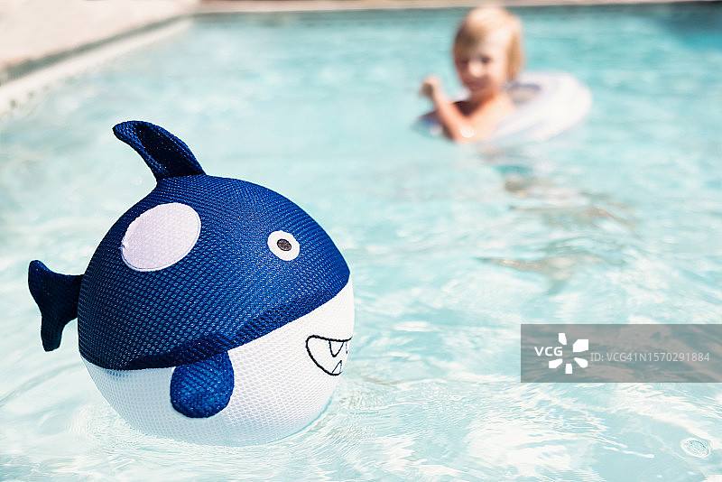 在泳池里玩鲨鱼球的小男孩图片素材