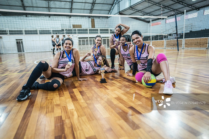 女排队员在运动场上赢得比赛后庆祝的肖像图片素材