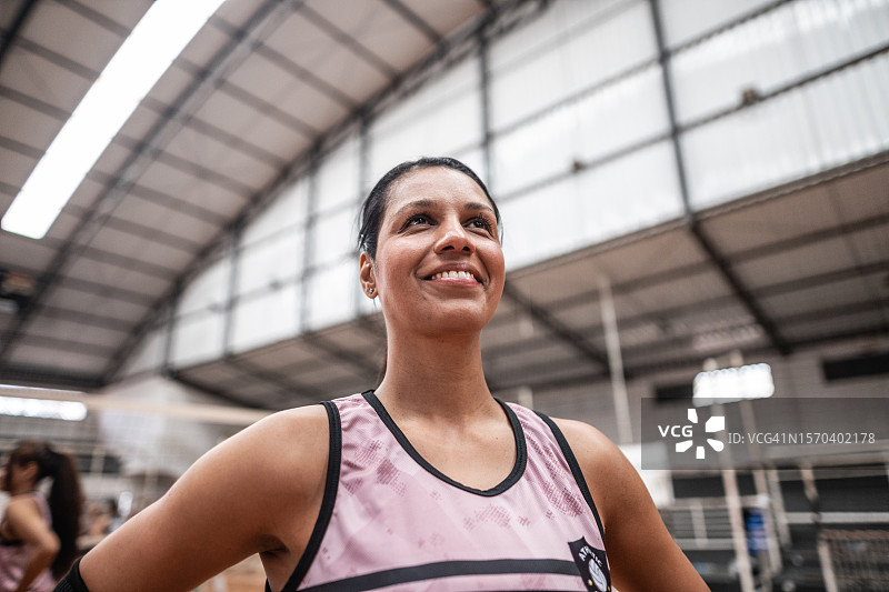 中年女排球员在运动场上沉思图片素材