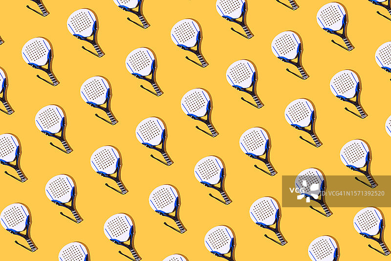 黄色背景上的白色、黑色和蓝色球拍图案图片素材