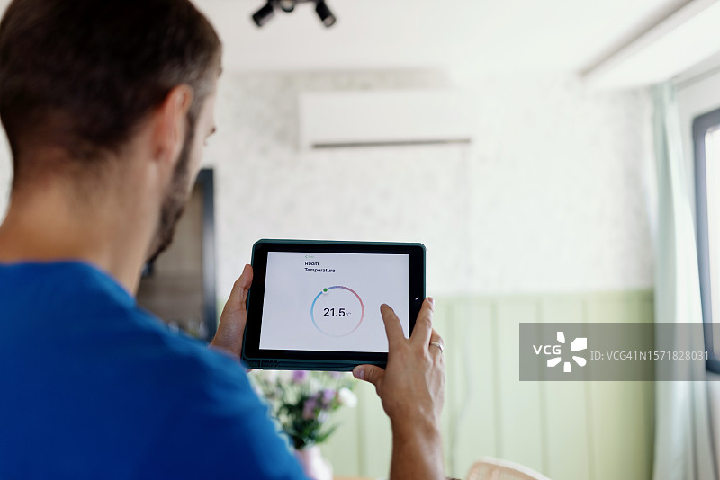 男人使用数位平板电脑检查空调温度图片素材