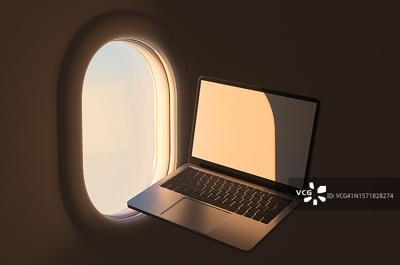 黎明时分，客机内飞机舷窗和米色屏幕笔记本电脑的侧视图图片素材
