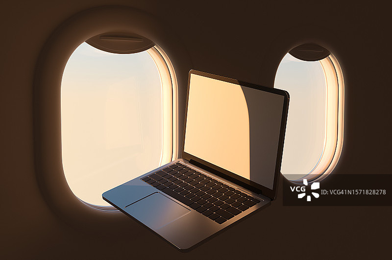 日落时分客机舷窗和笔记本电脑图片素材