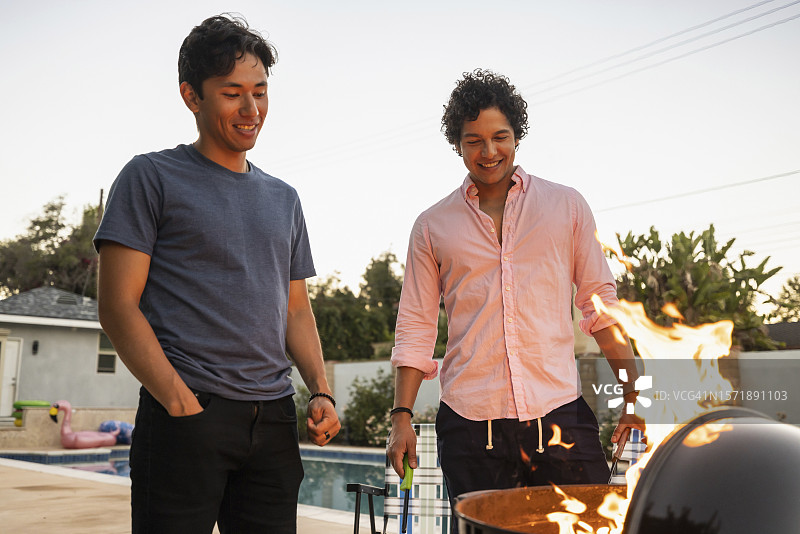 年轻男人在后院烧烤派对上聊天图片素材