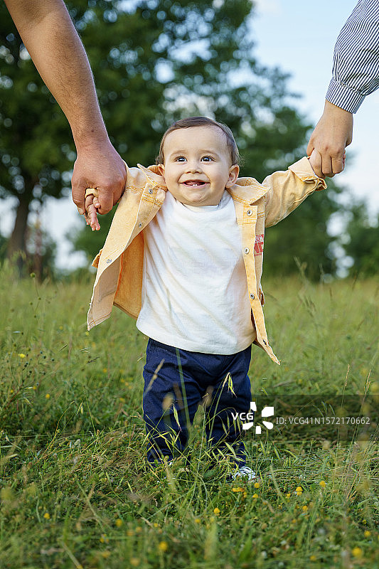 可爱的幼儿宝宝牵着父母的手图片素材