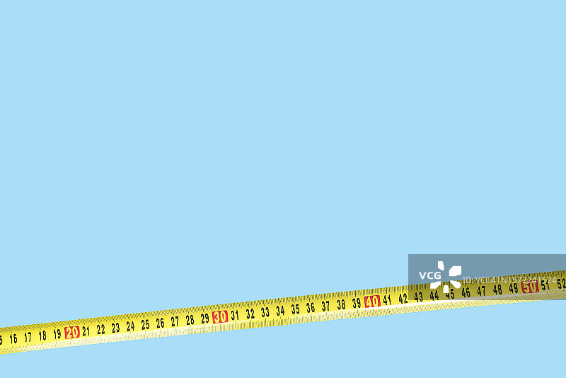 蓝色背景上的黄色卷尺图片素材