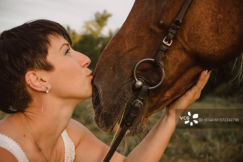 亲吻白色马口鼻的女子肖像图片素材