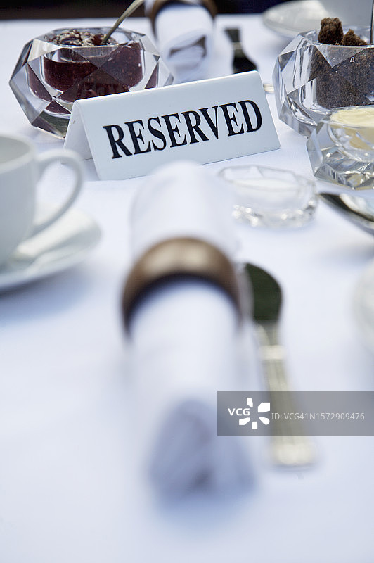 特写：餐巾和预订标志的早餐桌图片素材