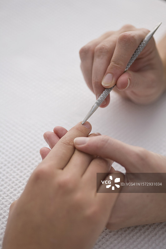 美甲师用角质层推杆推女性角质特写图片素材