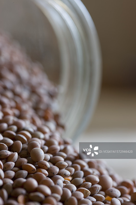 玻璃罐中倾泻而出的扁豆特写图片素材