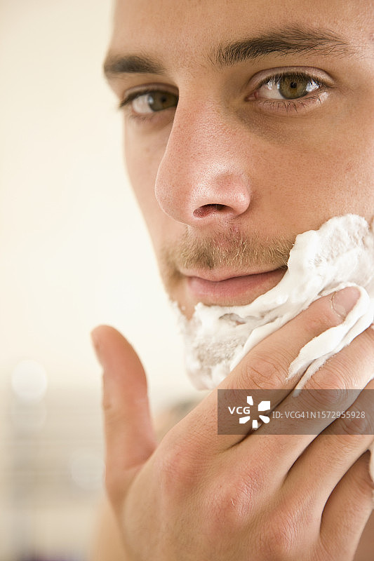 涂抹剃须膏的年轻男人特写图片素材