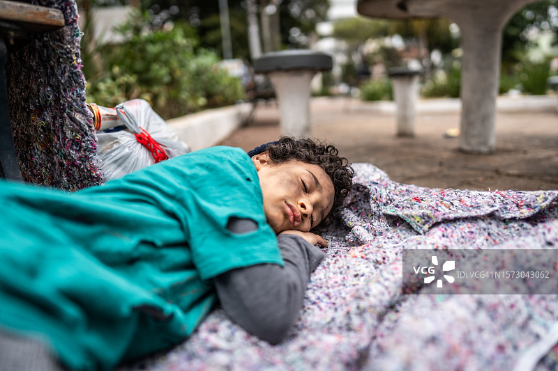 睡在户外地板上的无家可归的儿童图片素材