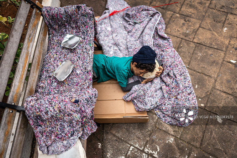 睡在户外地板上的无家可归的儿童图片素材