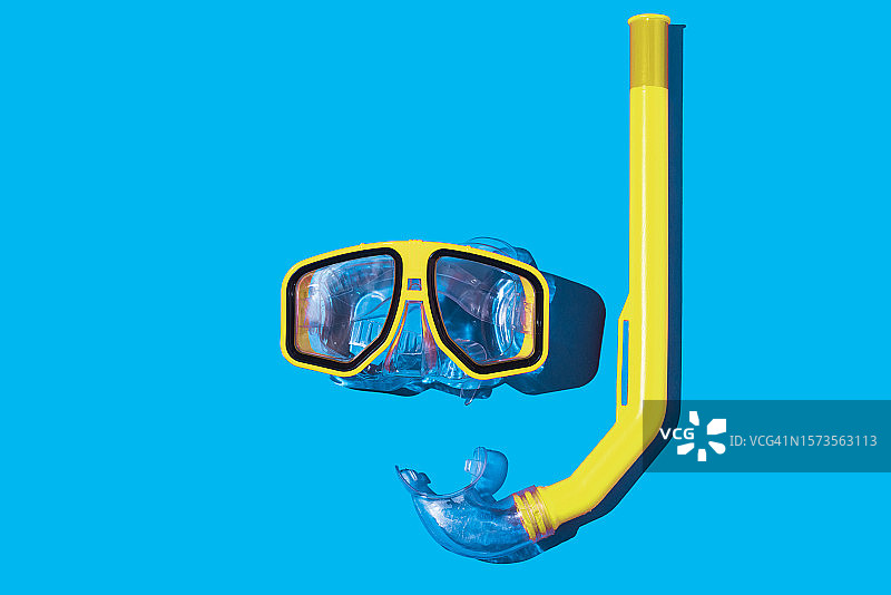蓝色背景上的潜水镜和黄色呼吸管：夏季水下潜水概念图片素材