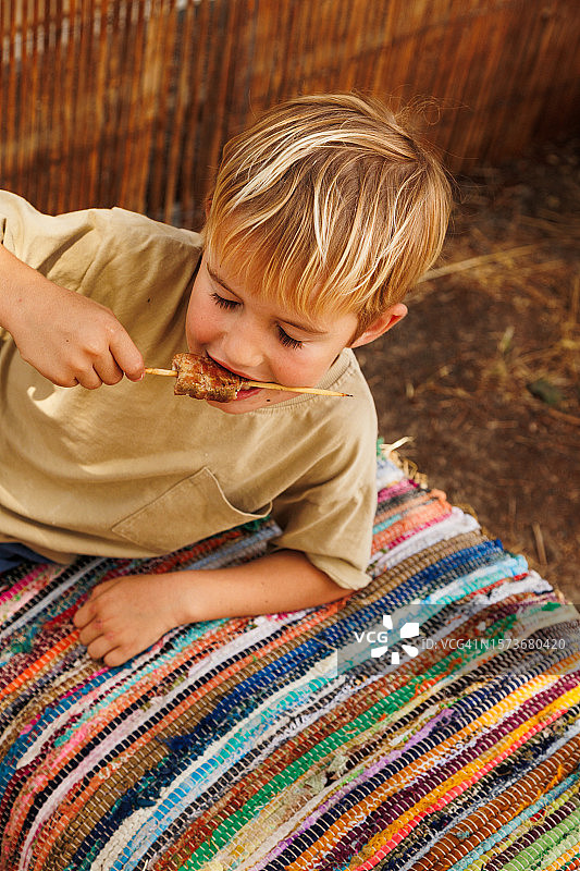 金发男孩在传统街头咖啡馆享用餐点图片素材