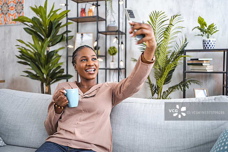 黑人妇女在客厅喝咖啡自拍图片素材