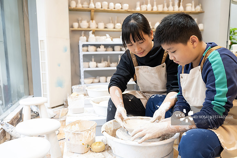 女士和儿子一起制作手工陶器图片素材