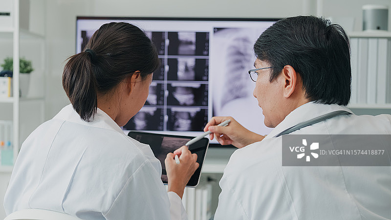 医院里亚洲医生团队电脑查看X光片图片素材
