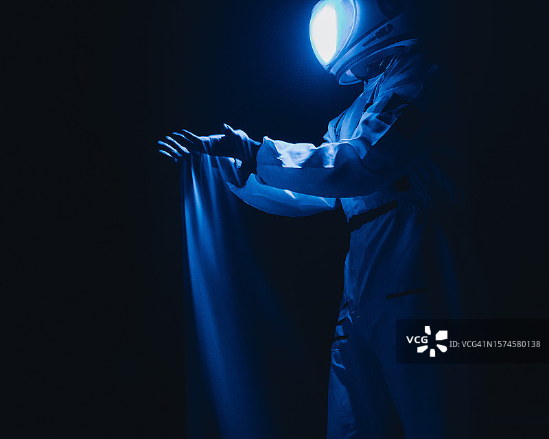 男性宇航员站在蓝色灯光下的侧面照，德克萨斯州莫纳汉斯，美国图片素材
