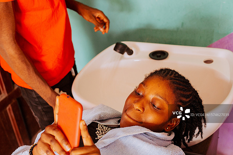 年轻理发师为顾客理发，沙龙工作，加纳特马图片素材