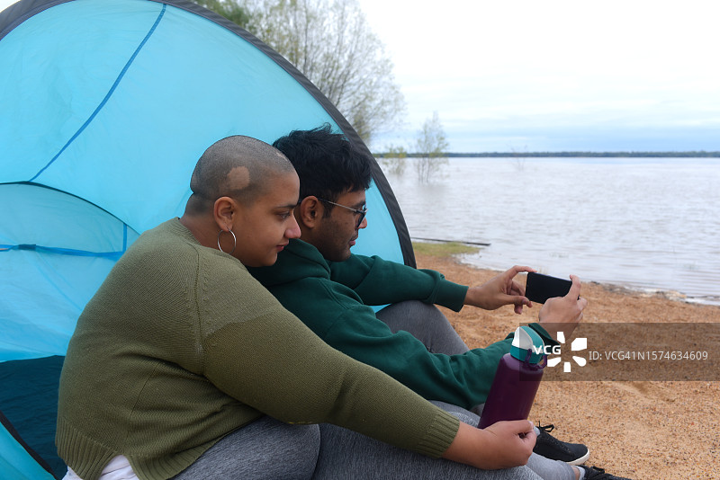 情侣坐在河边欣赏风景图片素材