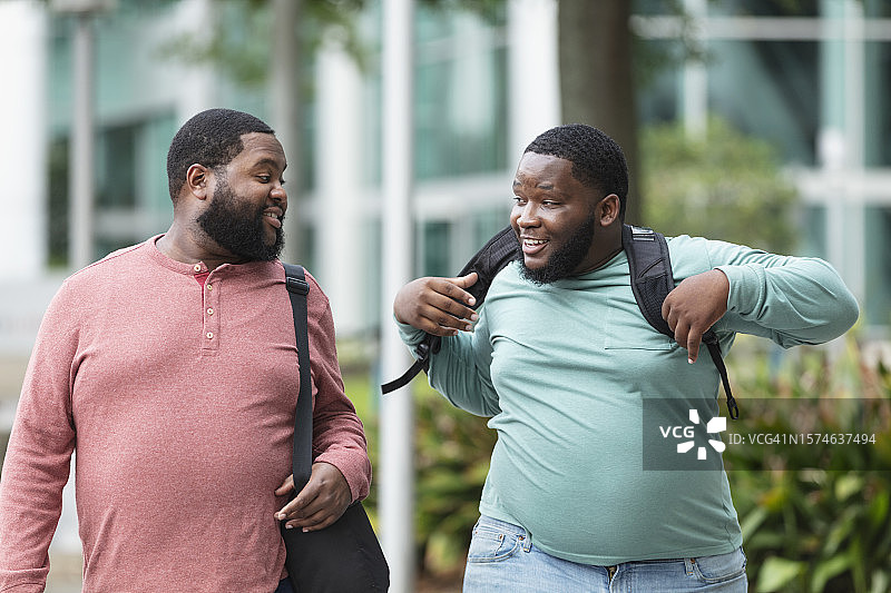 在城市里交谈的两名身材魁梧的黑人男子图片素材