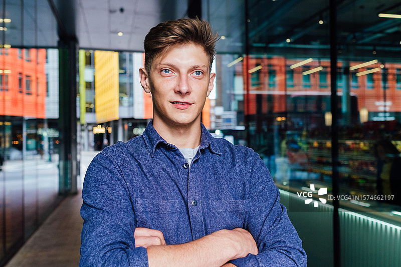 内省的男人交叉双臂，目光移开图片素材