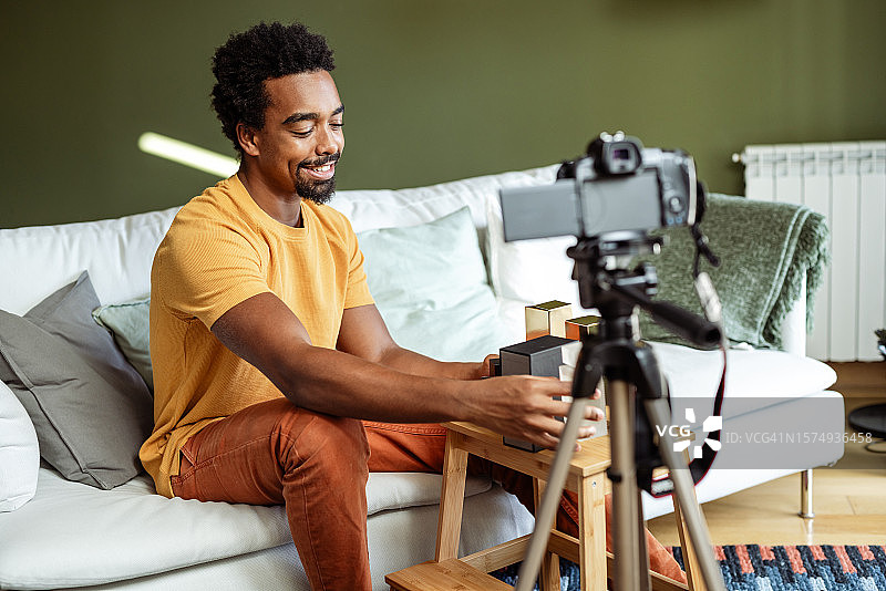 香水爱好者：年轻男人录制迷人的香水Vlog图片素材