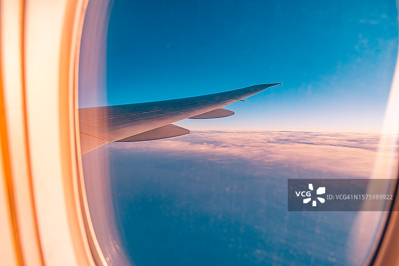 透过飞机舷窗看到的日落美景，旅行度假概念图片素材