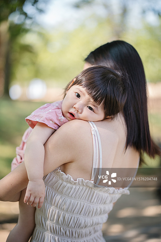 年轻母亲抱着女婴的背影图片素材