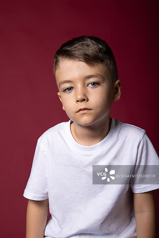 红色背景上的小男孩肖像图片素材