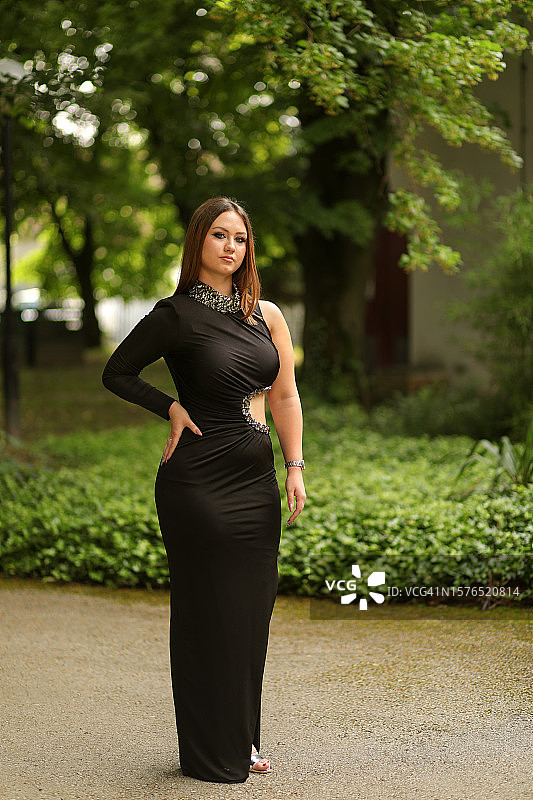 年轻女人站在树木旁人行道上图片素材