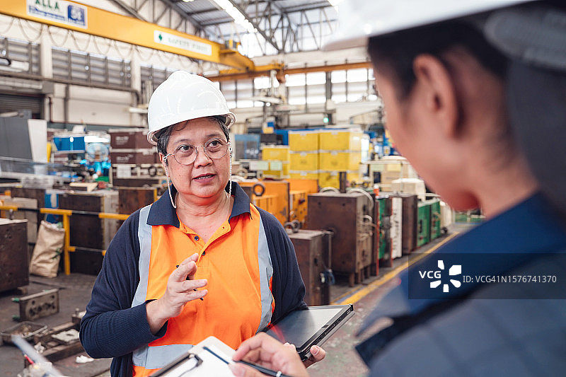 年长的女主管在工厂培训工程师图片素材