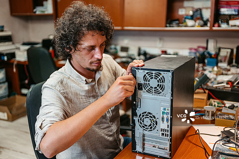 男人在工作室组装台式电脑图片素材