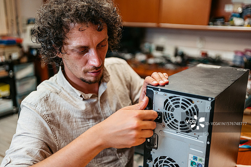 男人在工作室组装台式电脑图片素材