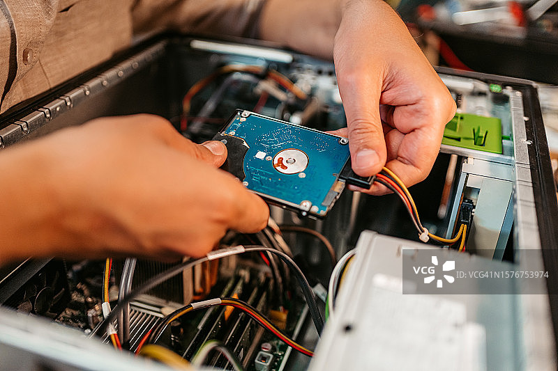 在工作室安装硬盘的年轻人图片素材