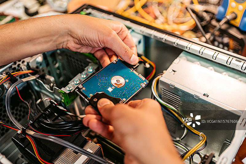 在工作室安装硬盘的年轻人图片素材