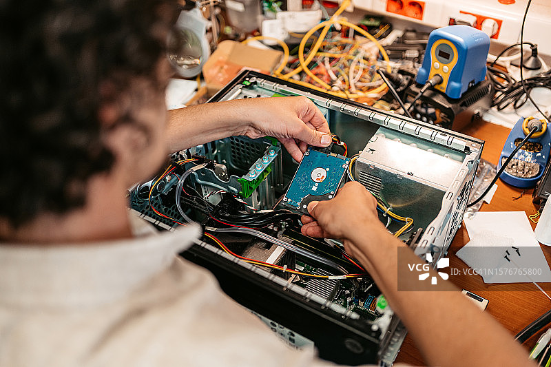 年轻男人在工作室组装台式电脑图片素材