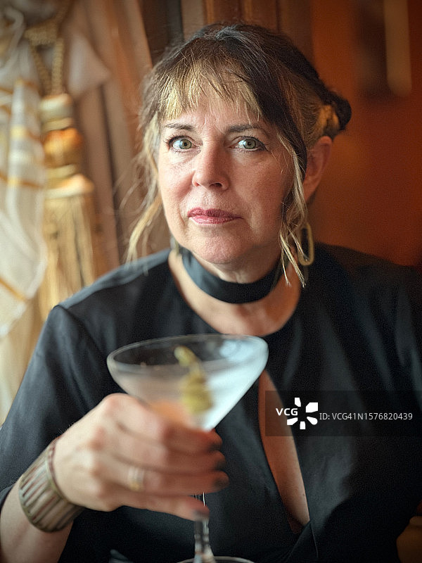 手持鸡尾酒的中年妇女图片素材