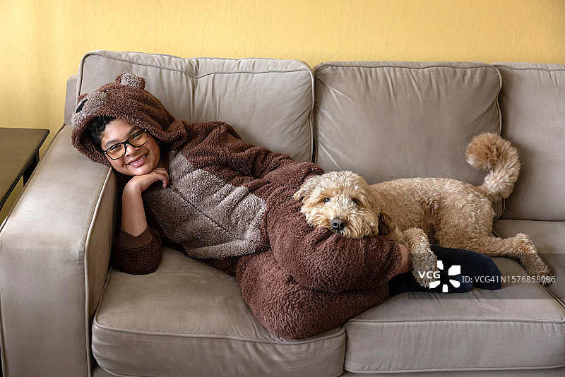 男孩身穿熊套装和金毛犬图片素材