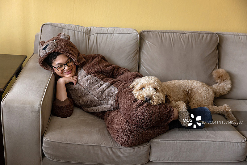 男孩身穿熊套装和金毛犬图片素材