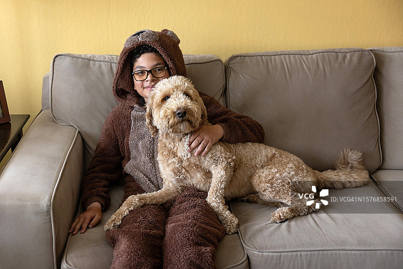 男孩身穿熊套装和金毛犬图片素材
