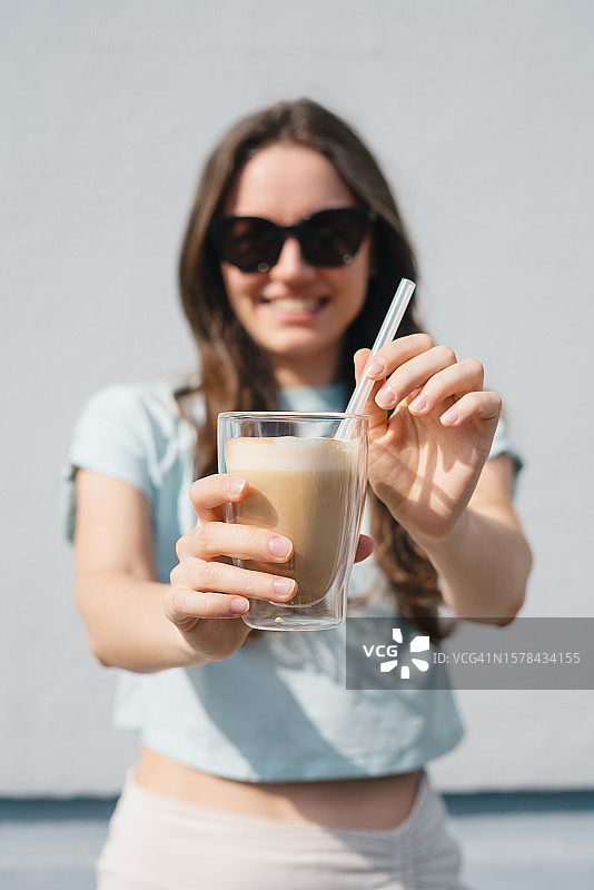 拿着冰咖啡的快乐女人图片素材