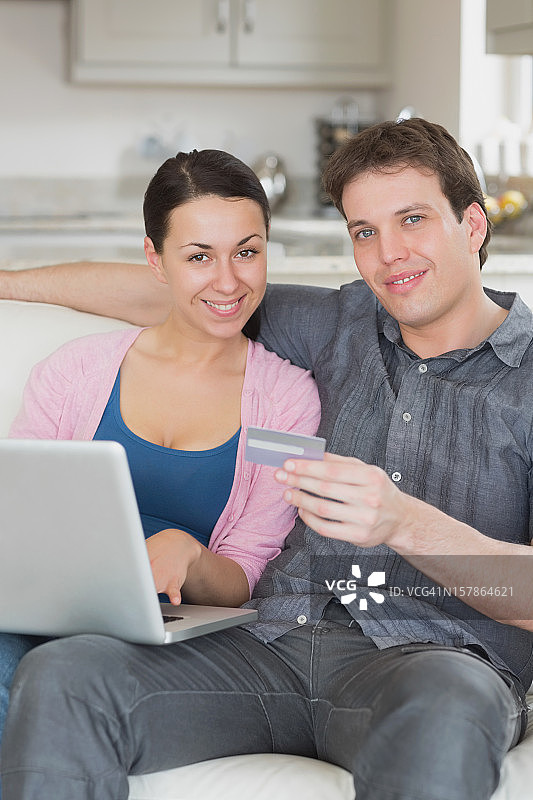 两人在沙发上使用笔记本电脑图片素材