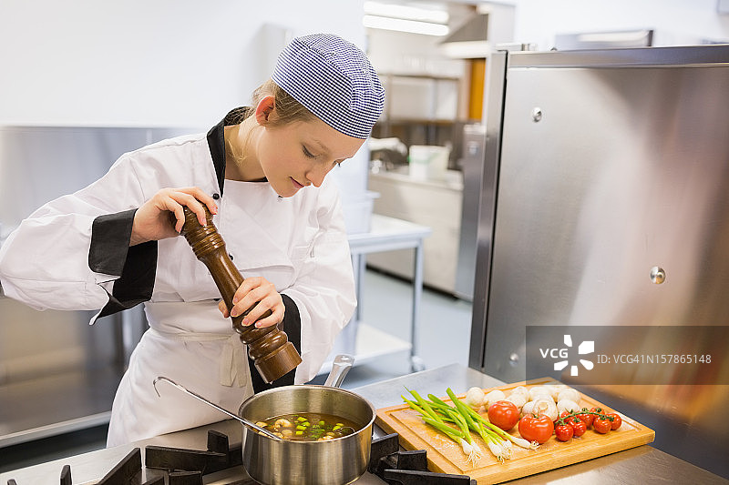 女人在厨房给汤调味图片素材