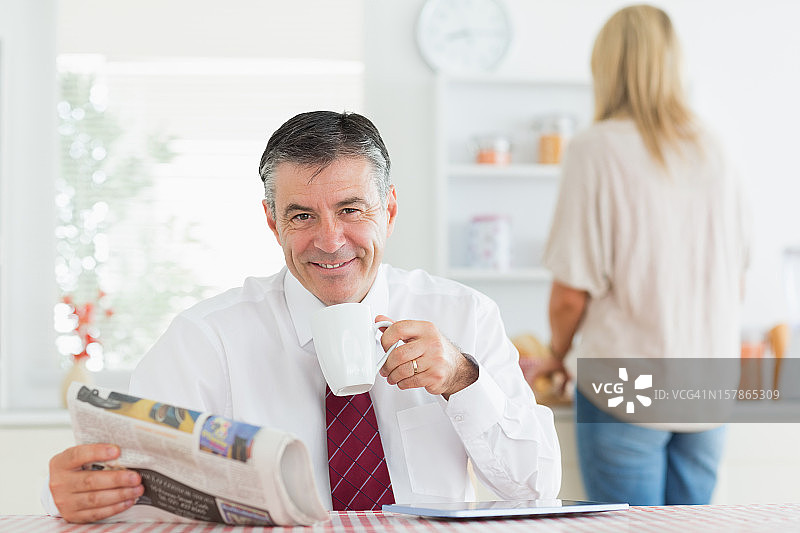 男人坐在厨房的桌旁，上班前喝着咖啡图片素材