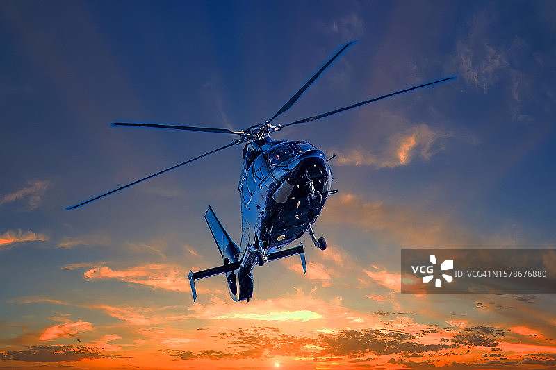 日落时分直升机飞过天空图片素材