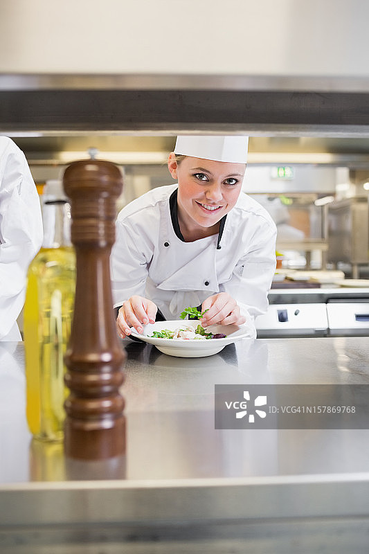 微笑的厨师装饰沙拉并向上看图片素材